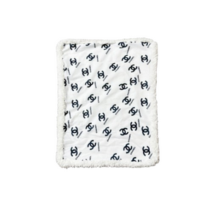 White and black Chanel inspired dog bed with interlocking logo pattern and plush sherpa border trim