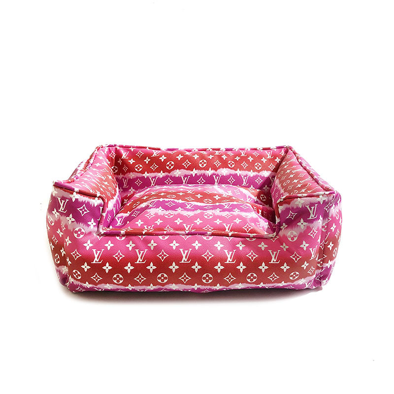 Pink gradient monogram dog bed showing structured bolster sides and plush interior