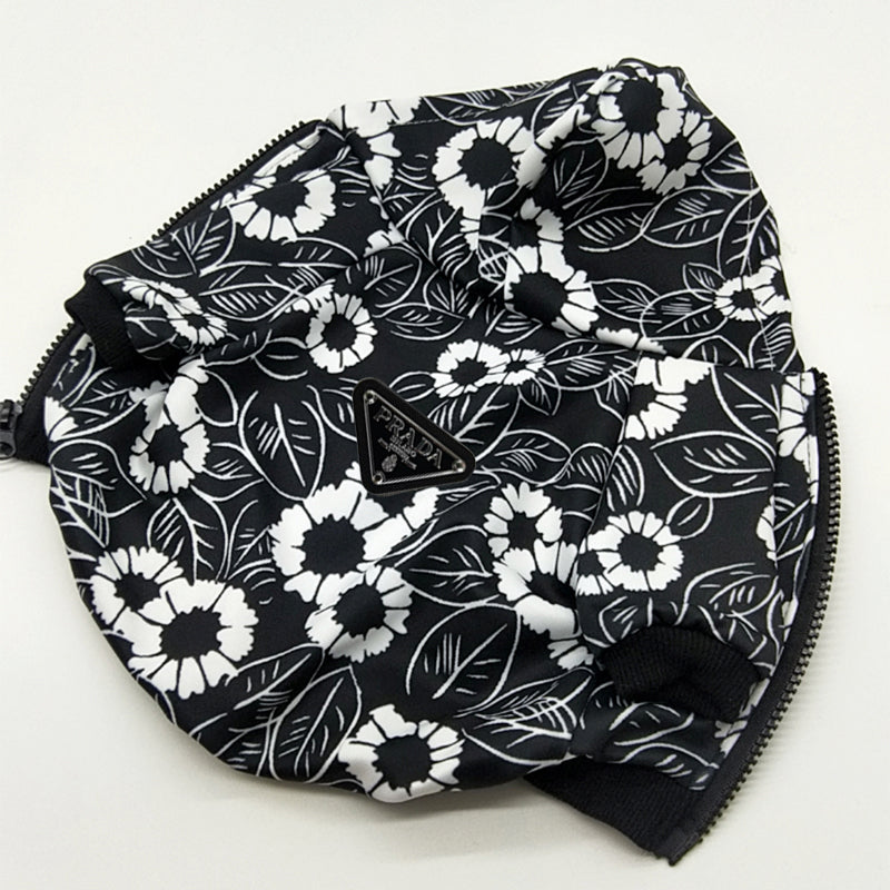 Close-up black floral print dog hoodie showing Pawda triangle logo and pocket detail