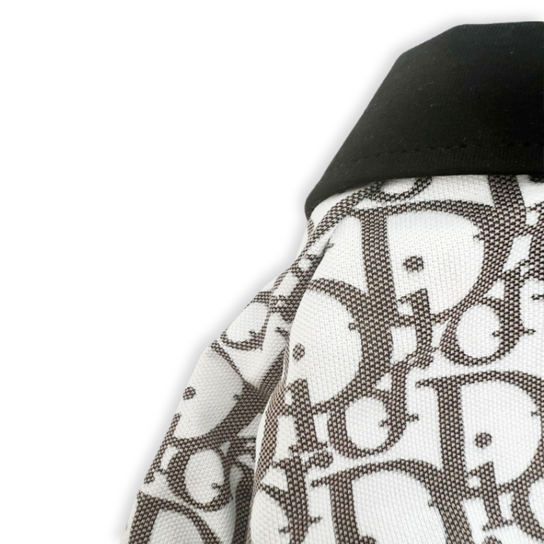 Close-up of Dior oblique pattern on white dog polo shirt with navy trim
