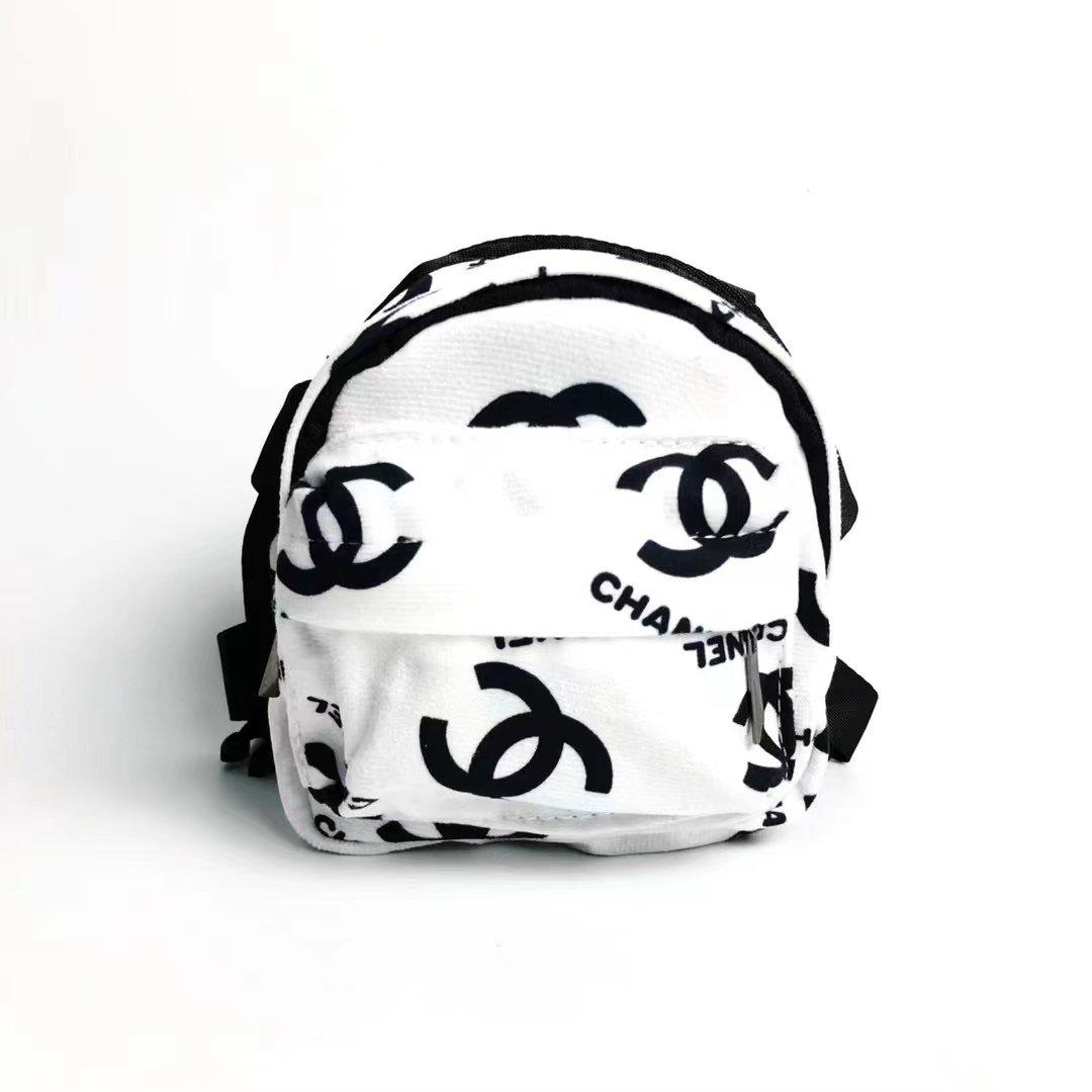 White canvas dog backpack with black Chanel inspired logos and adjustable straps