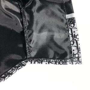 Close-up detail of black nylon construction and oblique print pattern on windbreaker