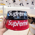 Red dog bowl with white Supreme branding being held in hand